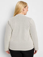 Off-white knit top with black chevron pattern, long sleeves, high neck. Model's back view.