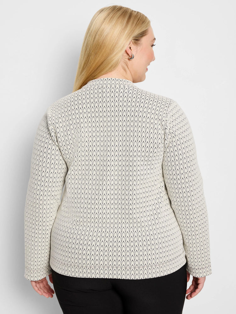 Off-white knit top with black chevron pattern, long sleeves, high neck. Model's back view.