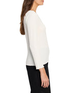 Cream bubble knit top with long sleeves, ruffled cuffs, and hem. Model is shown in profile.