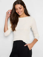 Off-white bubble knit top with boat neck, 3/4 sleeves, and ruffled cuffs.