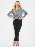 Long-sleeved, V-neck knit top with blue, brown, & white speckled circular 'sand dollar' patterns.