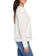 Off-white seamed texture long-sleeve top with vertical cut-out details on sides and hem.