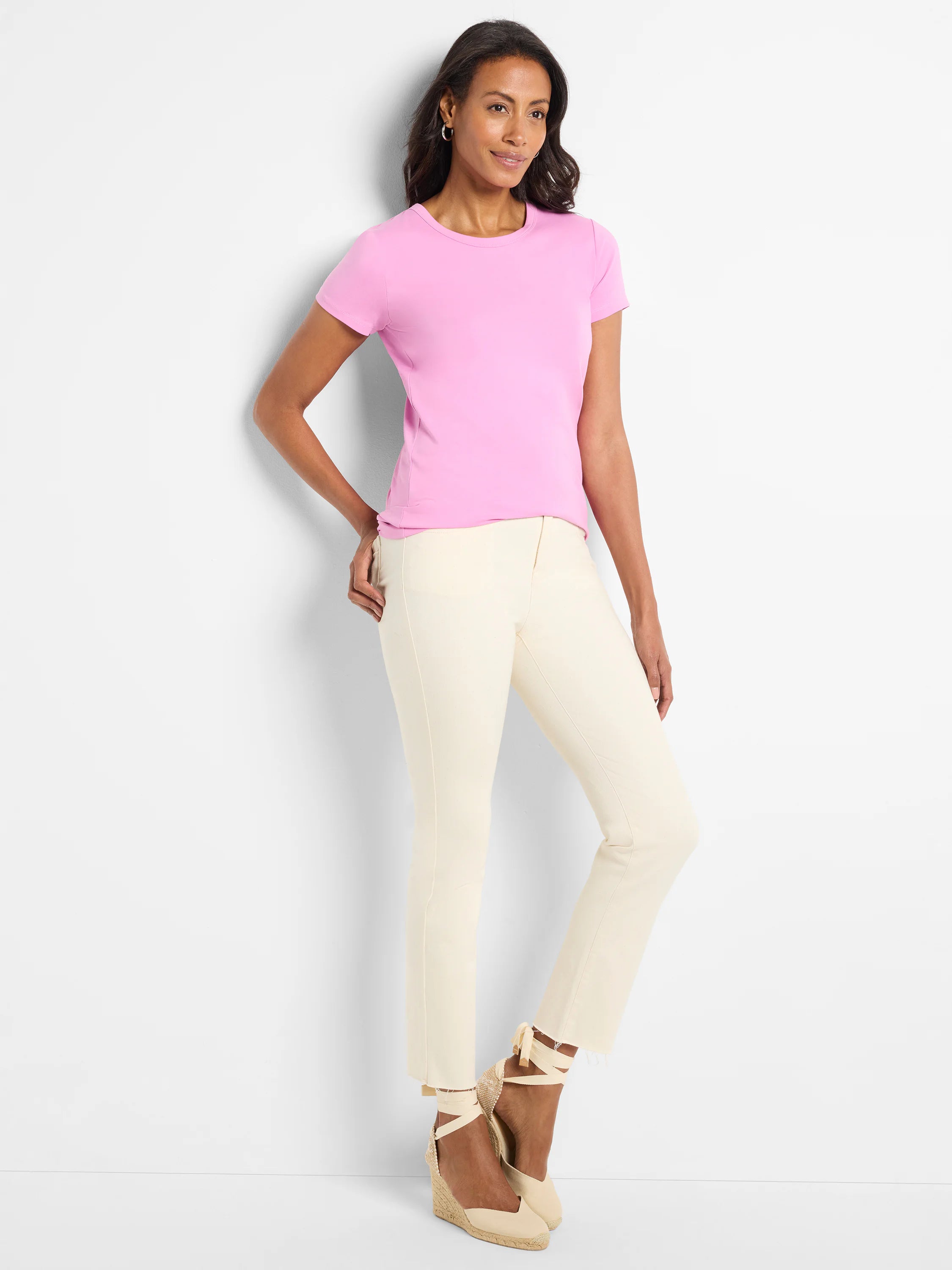 Pink short-sleeve crew neck t-shirt with a smooth finish, worn by a model.
