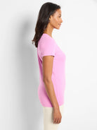 Pink, fitted knit crew neck t-shirt with short sleeves, shown on a woman in profile.