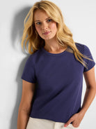 Model wears a navy blue crew neck t-shirt with short sleeves.