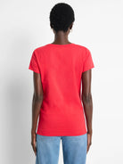Red short-sleeve crew neck t-shirt on a person's back. Smooth knit fabric.