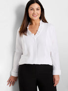 White shirt with ruffled V-neck, long sleeves, and wide cuffs.