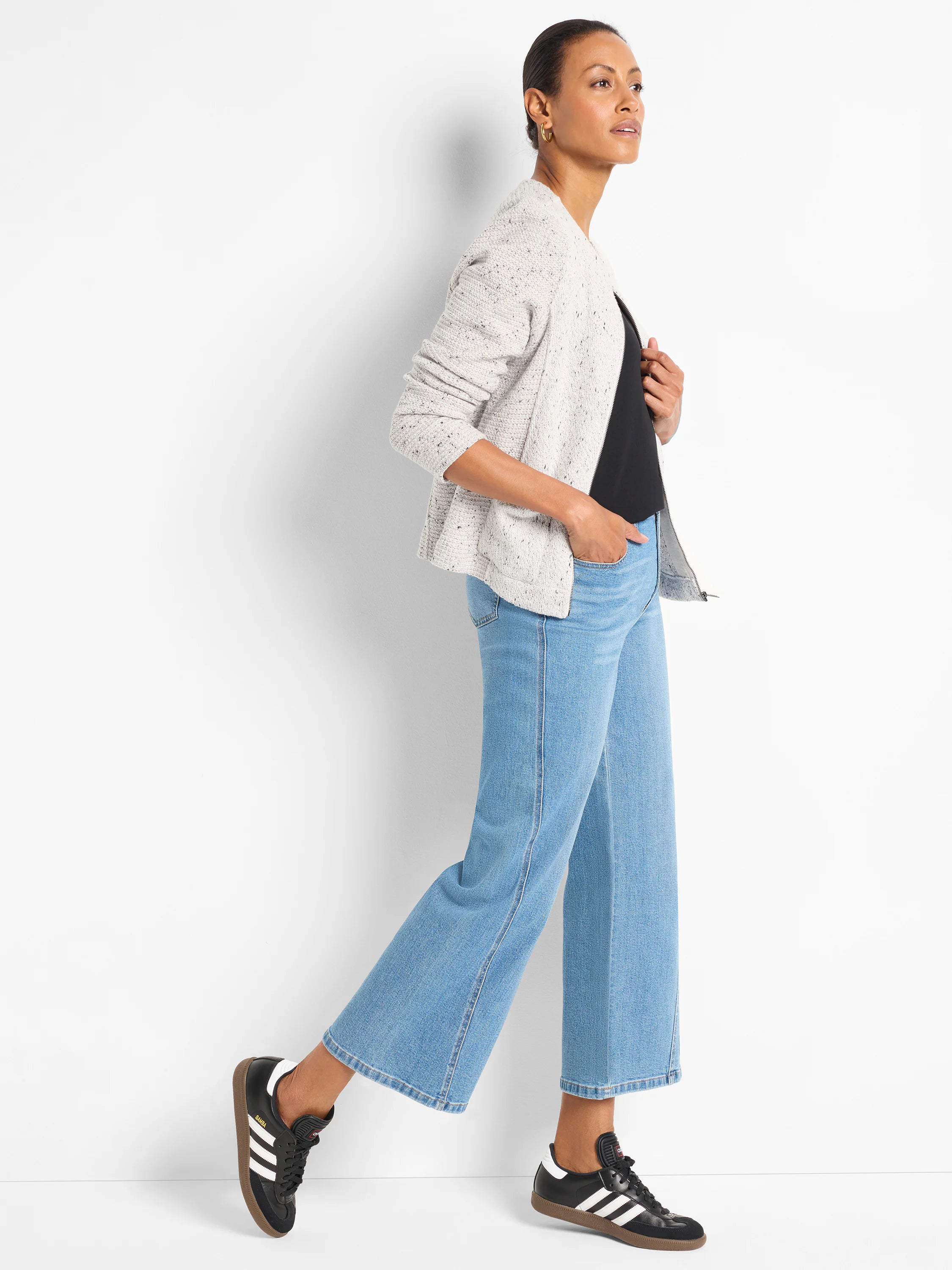 Black knit tank with a round neckline, shown partially beneath an open cardigan.