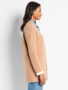 Tan knit jacket with open front & long sleeves. Reversible; shows white cuff lining & hint of light gray on reverse side.