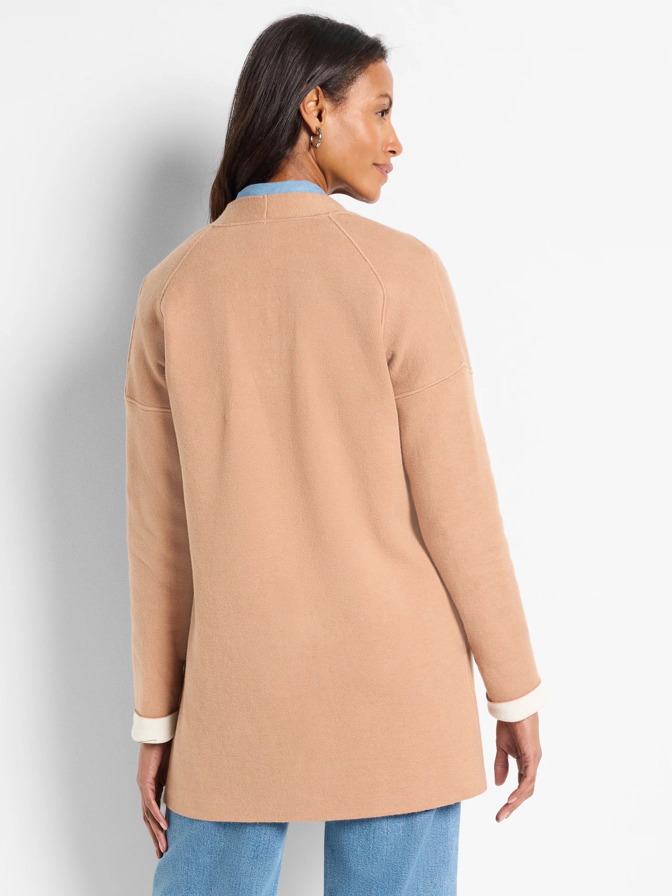 Tan knit jacket, raglan sleeves. Cuffs folded to show off-white interior.