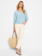 Pale blue V-neck sweater with long sleeves, ribbed cuffs, and a ribbed hem, worn by a model.
