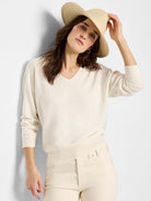 Light cream V-neck sweater, relaxed fit, with long sleeves and ribbed cuffs and hem.