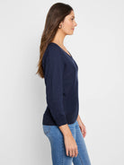 Navy blue V-neck sweater with long sleeves, ribbed cuffs and hem, modeled in profile.