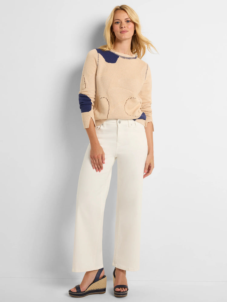 Beige sweater with navy blue pebble-like shapes and contrast stitching. Features small open-knit patterns.