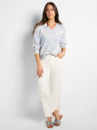 Light blue and white marled V-neck sweater with pointelle knit texture and patterned open holes.