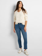 Ecru pointelle knit V-neck sweater with small heart-shaped perforations down the front.