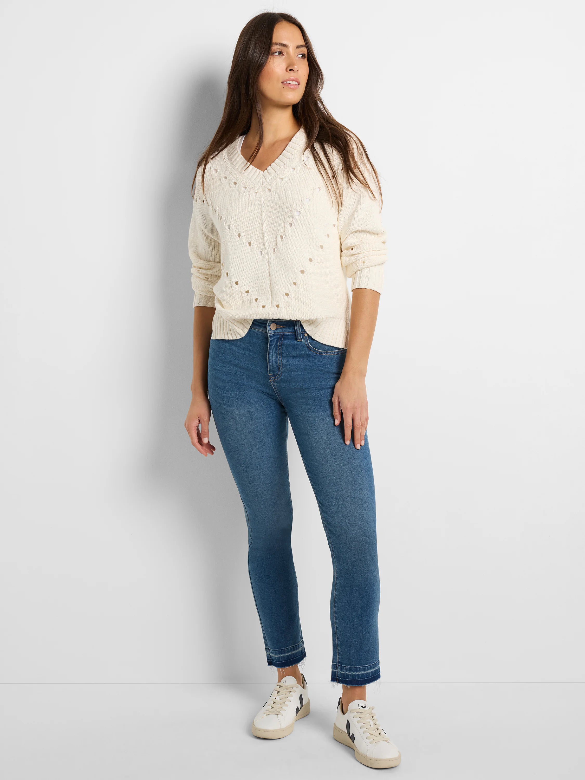 Ecru pointelle knit V-neck sweater with small heart-shaped perforations down the front.