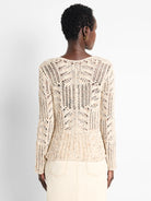 Cream open-knit sweater with tiny blue & orange speckles, forming a geometric pattern. Model shown from behind.