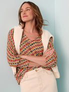 V-neck sweater with diagonal rope twist pattern in red, yellow, black, cream, and teal colors.