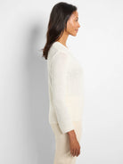 Off-white, loosely knit sweater.  Long sleeves, crew neckline.