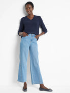 Navy blue v-neck sweater, textured knit.  Model also wears light wash jeans and dark flats.