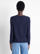 Dark navy blue, long-sleeved knit sweater, textured fabric.  Back view.