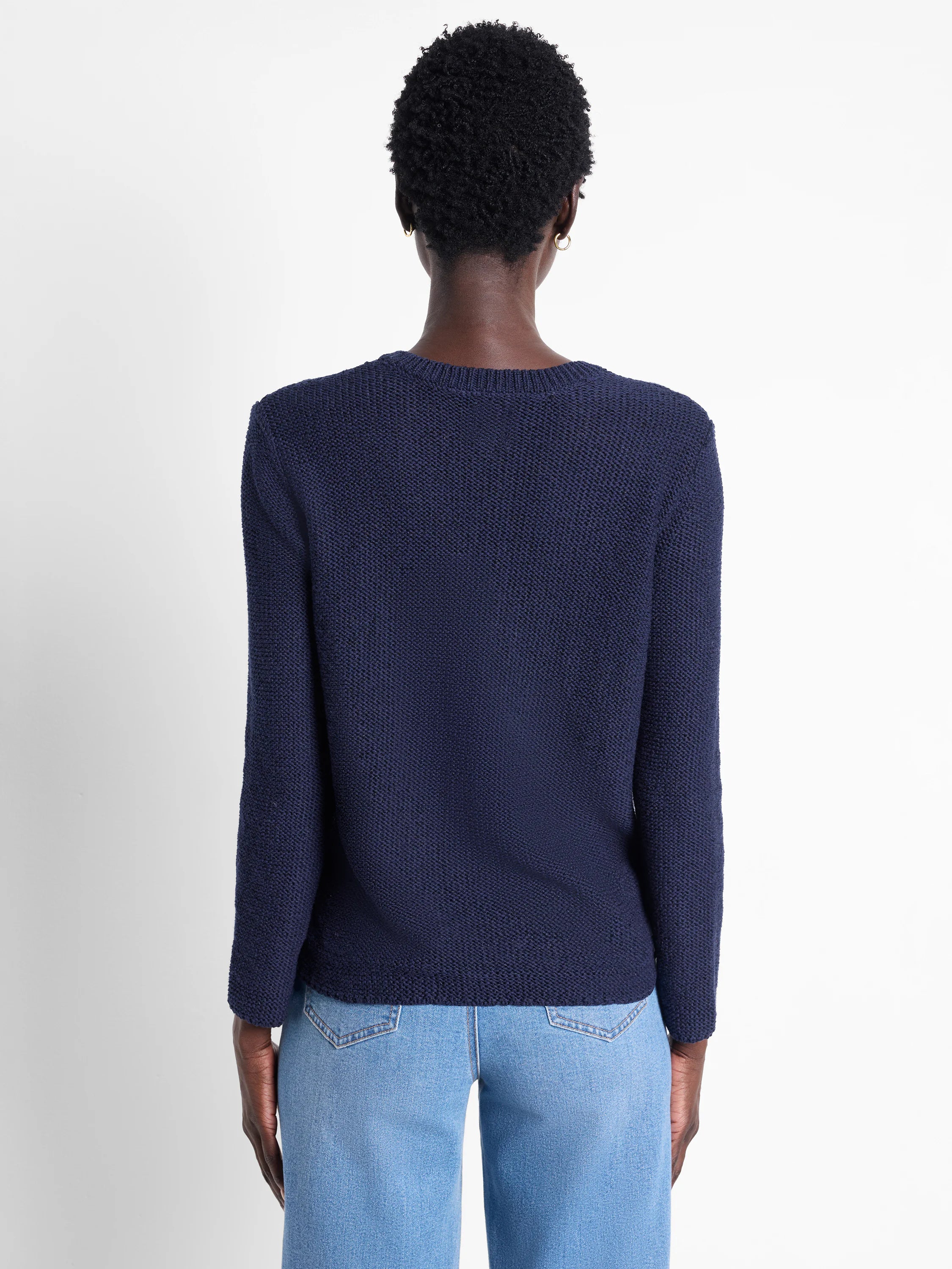 Dark navy blue, long-sleeved knit sweater, textured fabric.  Back view.