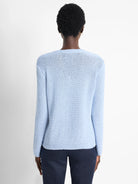 Light blue, long-sleeved knit sweater.  Textured knit fabric.  Shown from the back.