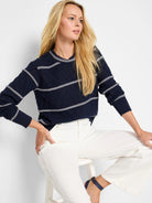 Navy blue pointelle knit sweater with thin, horizontal off-white stripes.  Crew neck, long sleeves.