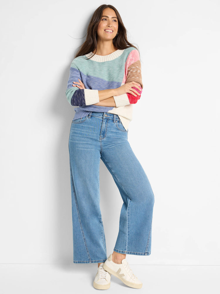 Color-blocked crewneck sweater in teal, periwinkle, cream, pink, and brown.  Image shows model wearing sweater.