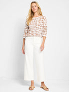 Cream-colored sweater with a textured, light brown diamond pattern. Long sleeves.