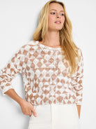 Off-white sweater with a taupe textured diamond pattern.  Long sleeves, loose fit.