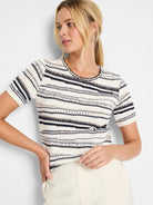 Cream-colored short-sleeve knit sweater with horizontal navy, brown, and silver stripes.  The neckline has a braided trim.