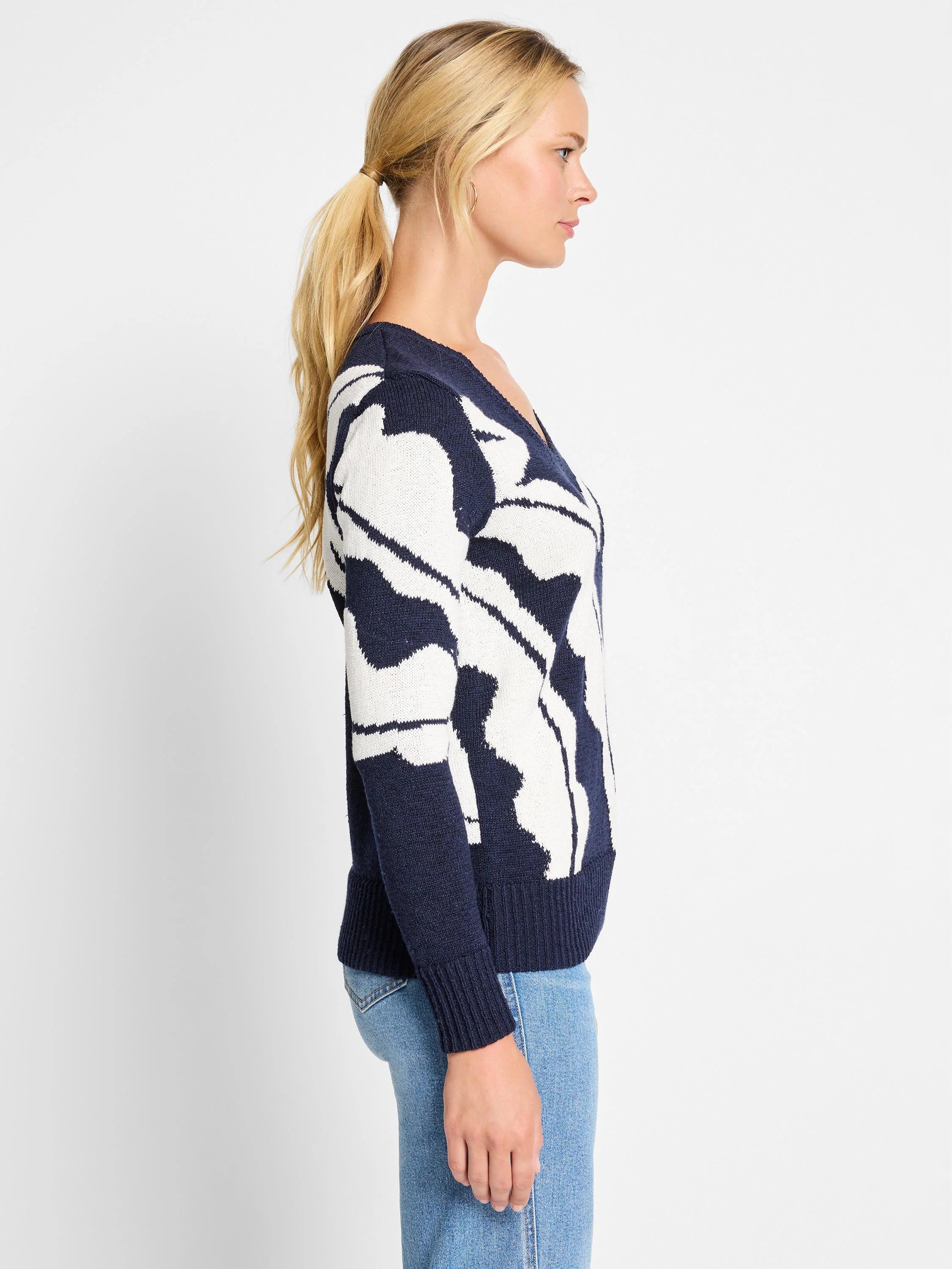 Navy blue sweater with an off-white abstract pattern.  V-neck, long sleeves, ribbed cuffs and hem.