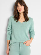 Mint green V-neck sweater with fine corded knit texture and long sleeves.