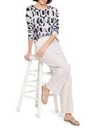 Long-sleeved cream sweater with black and beige ikat pattern.