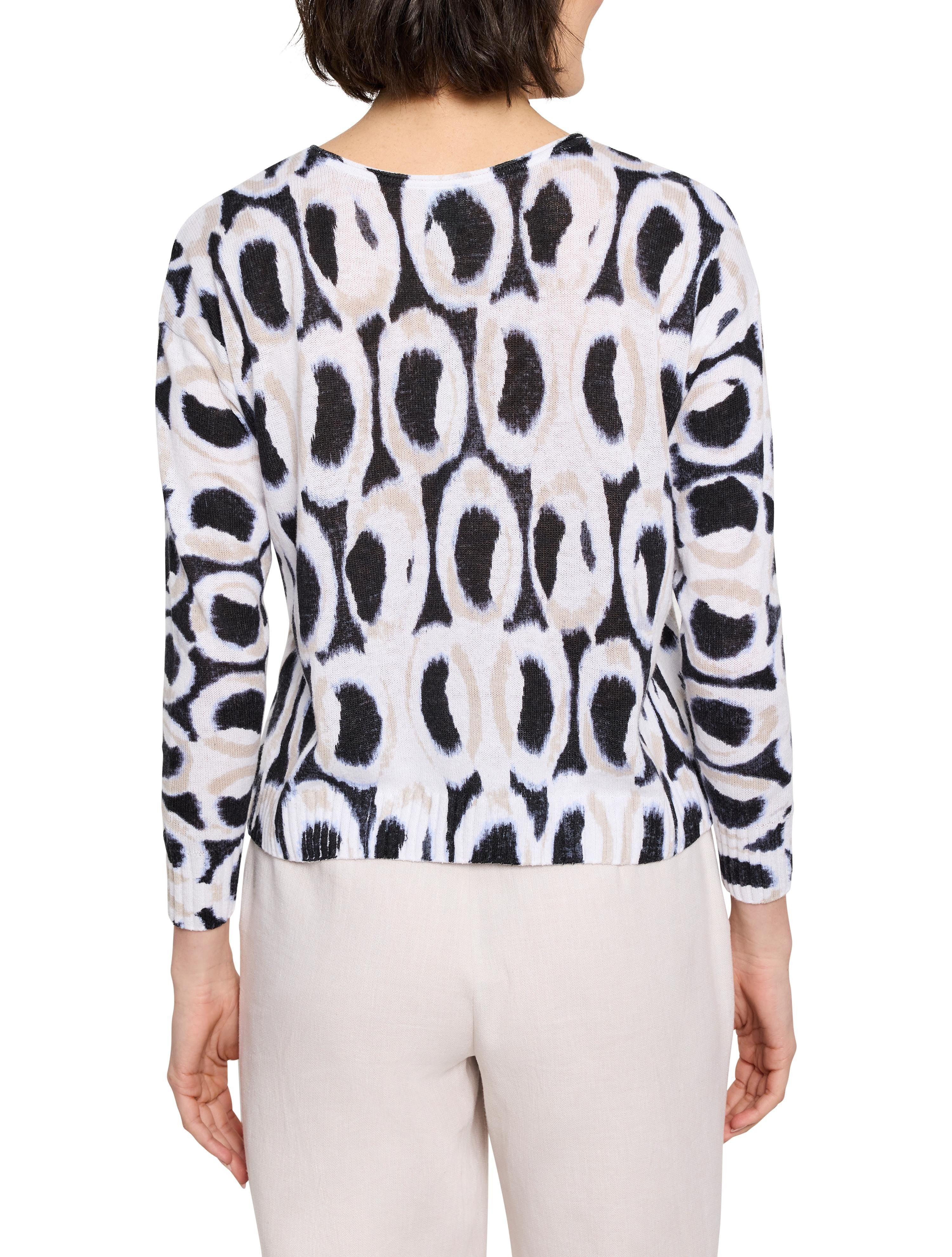 White sweater with black and beige ikat pattern. Long sleeves, crew neck.