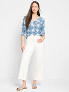 Light blue sweater with a V-neck and dark blue circular pattern. Long sleeves.