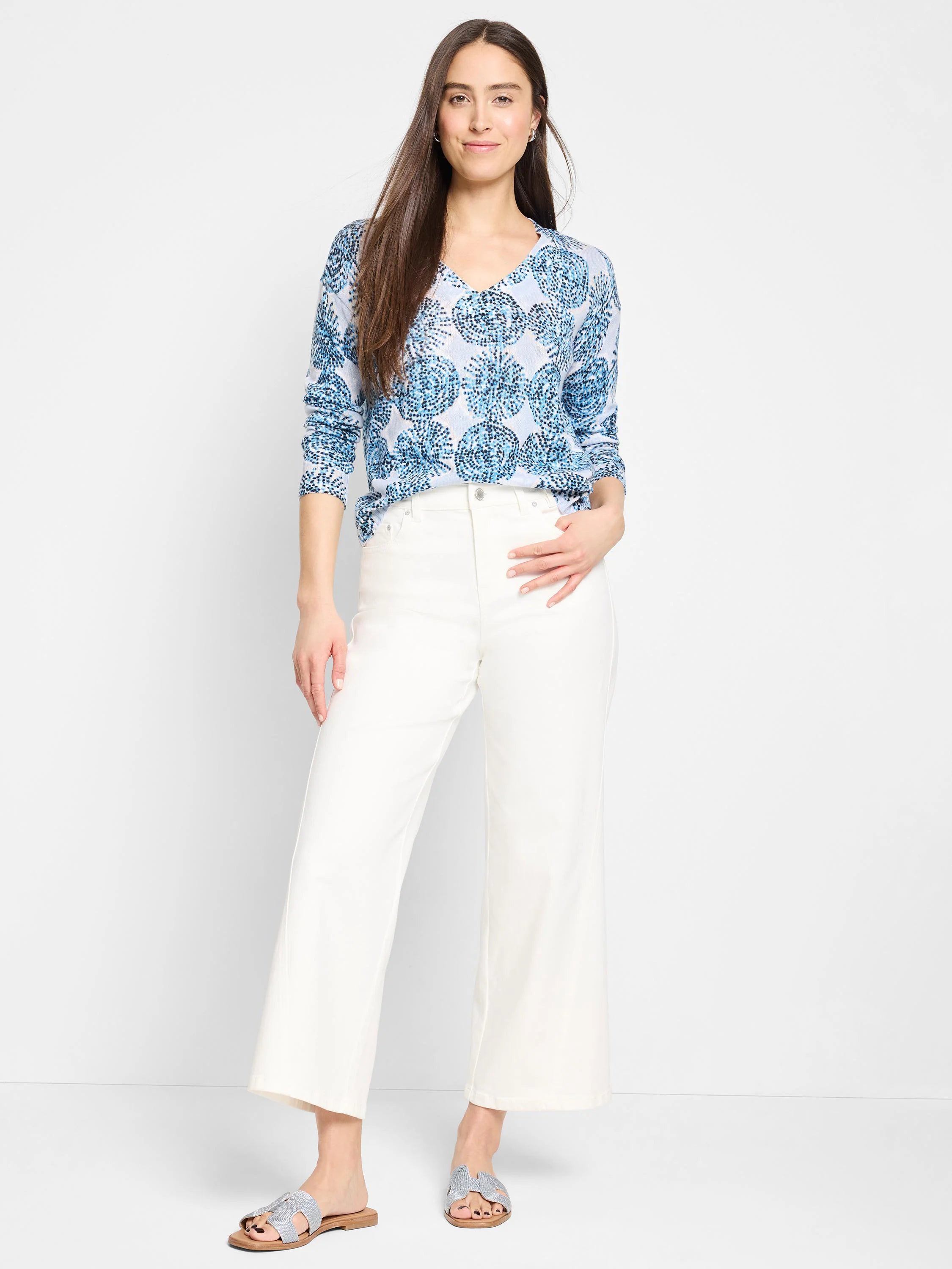 Light blue sweater with a V-neck and dark blue circular pattern. Long sleeves.