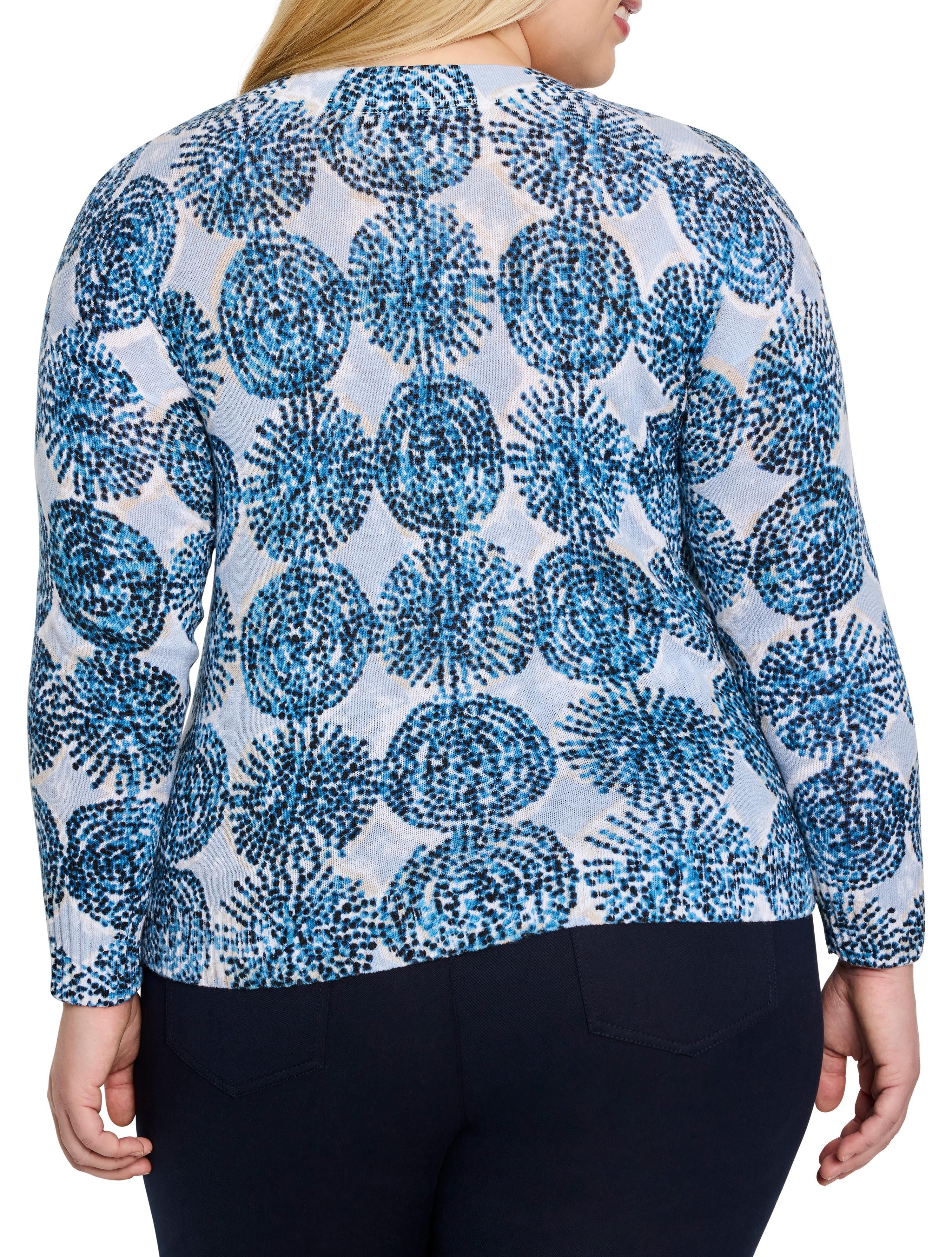 Light blue sweater with a pattern of dark blue, small, clustered circles.  Long sleeves.