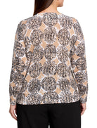 Beige sweater with a pattern of dark brown and black small dots forming circular shapes on a white and beige background....