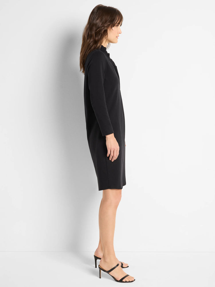 Black knit dress, knee-length, ruffled neckline, long sleeves.