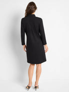 Black knit dress, 3/4 sleeves, A-line silhouette.  Rear view.