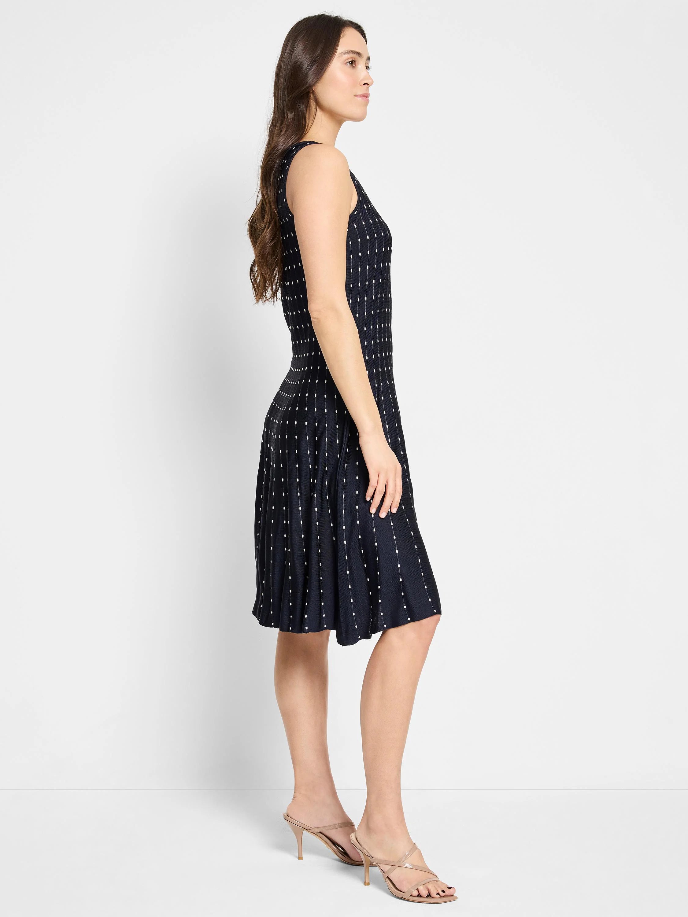 Dark navy sleeveless dress with a flared skirt and small, light-colored dots.  A-line silhouette.