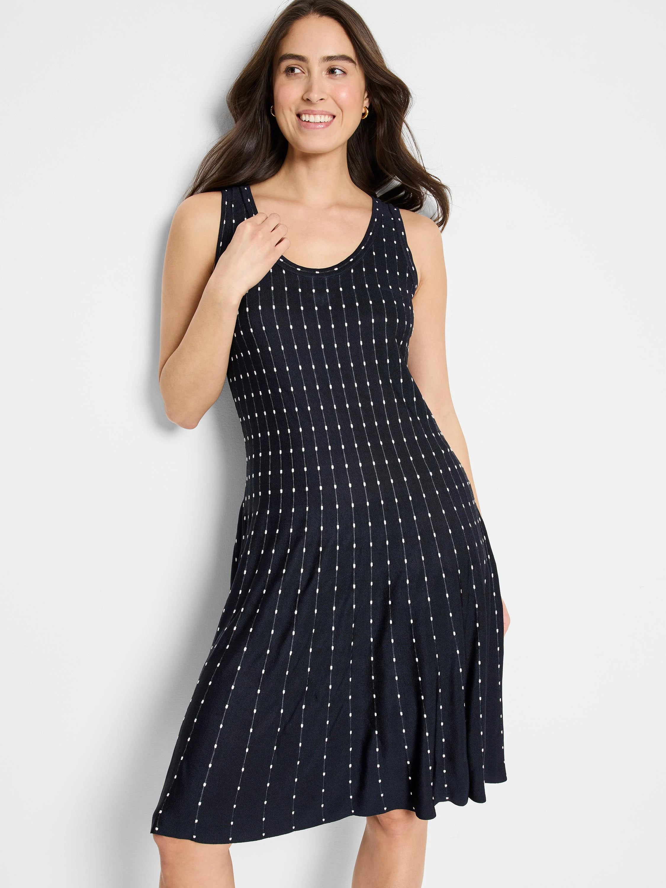 Black sleeveless A-line dress with small white vertical lines and dots.