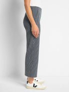 Side view of navy wide-leg jeans with thin white vertical stripes.