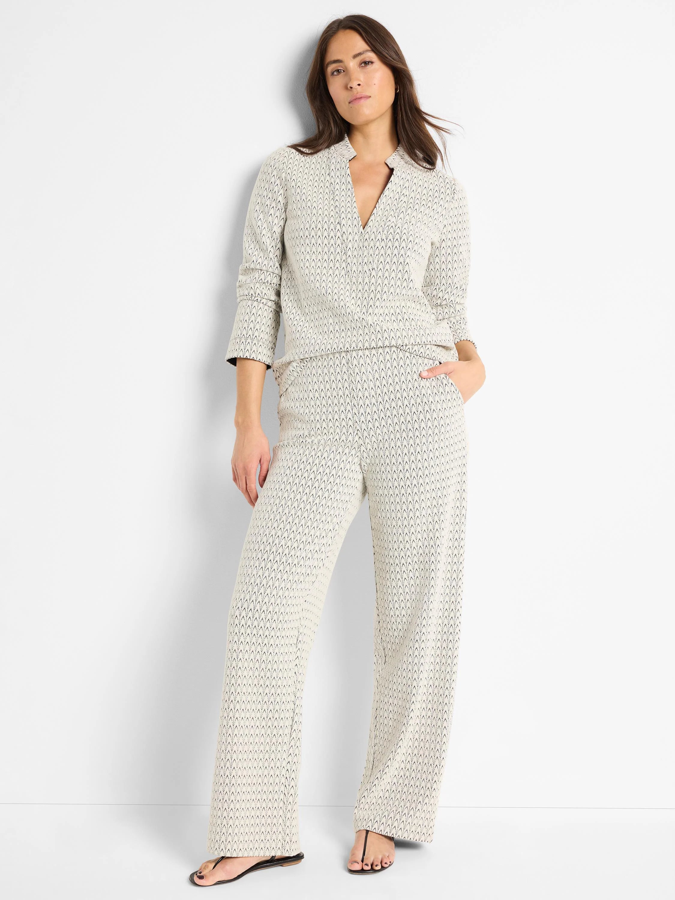 Off-white wide-leg pants with a subtle dark-grey swirl knit pattern.