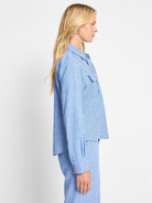 Light blue, collared shirt jacket; long sleeves, button front, chest pockets.