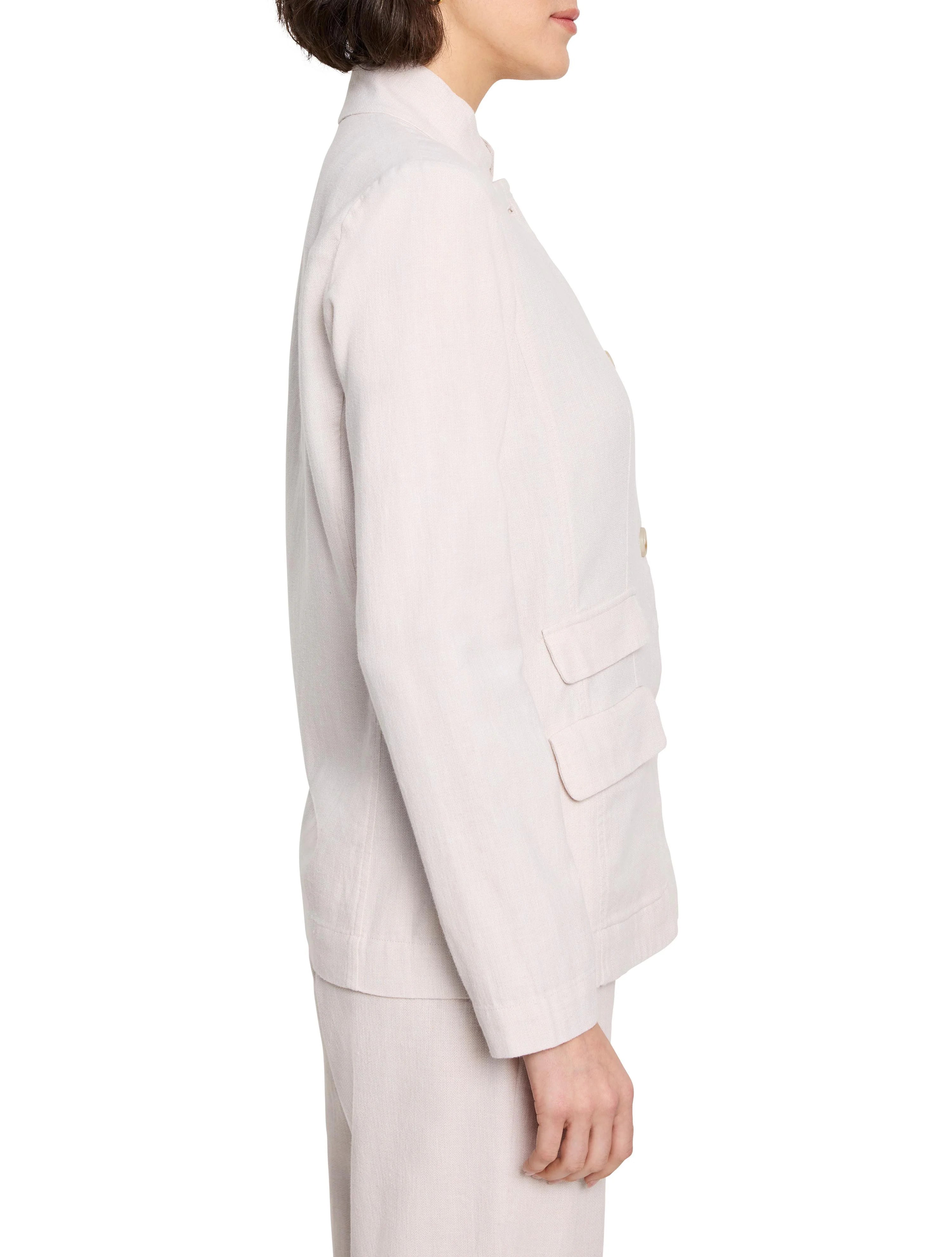 Light beige linen-cotton blazer, side view.  Features long sleeves, mandarin collar, and two pockets.  Buttons are gold.