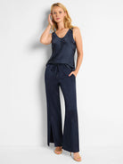 Navy blue scoop-neck tank and wide-leg pants; pants have side slits.